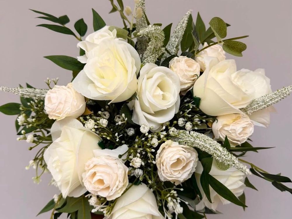 A bridal bouquet of ivory and cream roses with eucalyptus