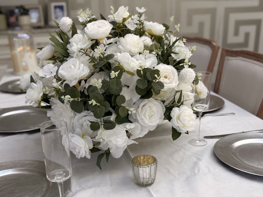 An ivory centrepiece on a laid table with chargers and glassware