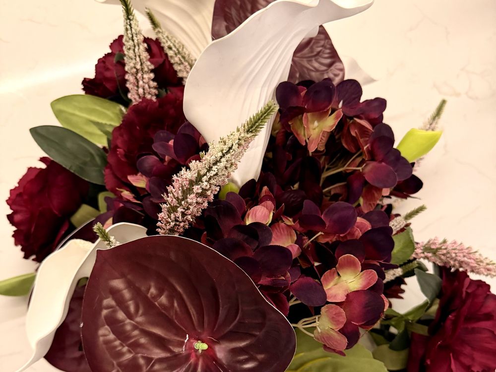 A burgundy bouquet of wine roses, dark hydrangea, aubergine anthurium and white calla lilies